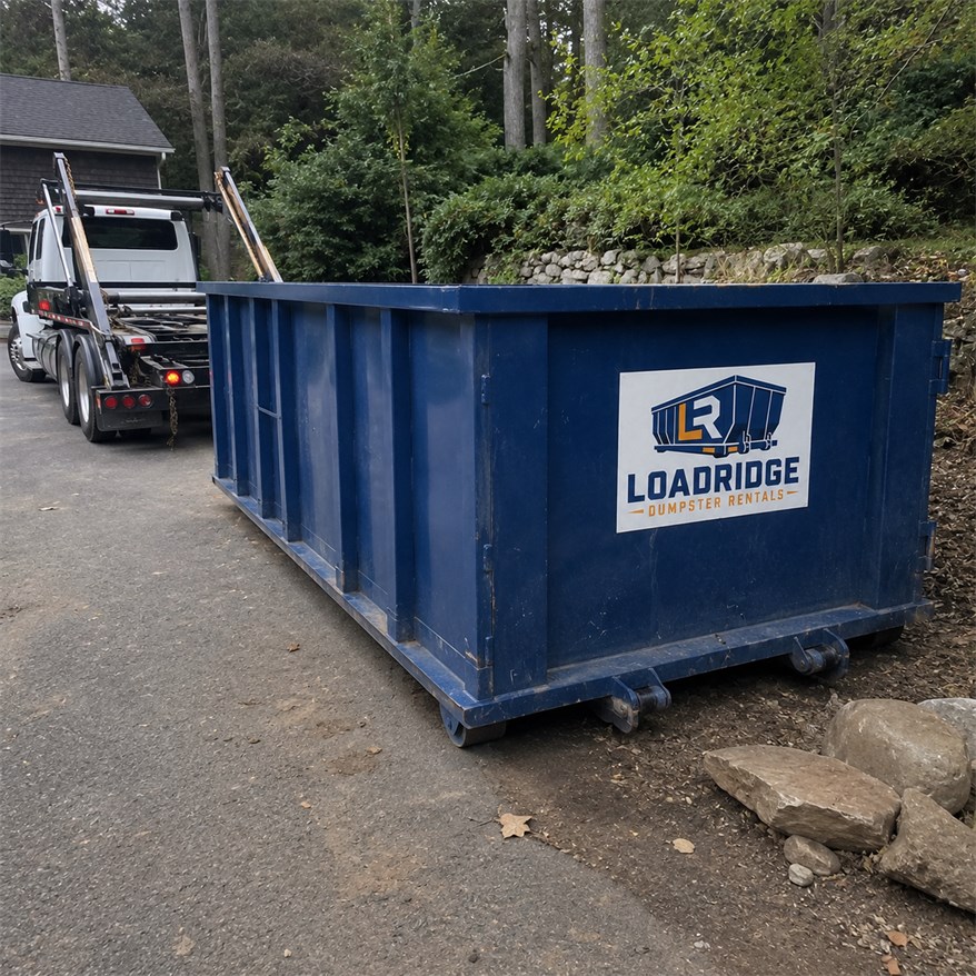 Roll-off dumpster delivery truck placing a Loadridge dumpster